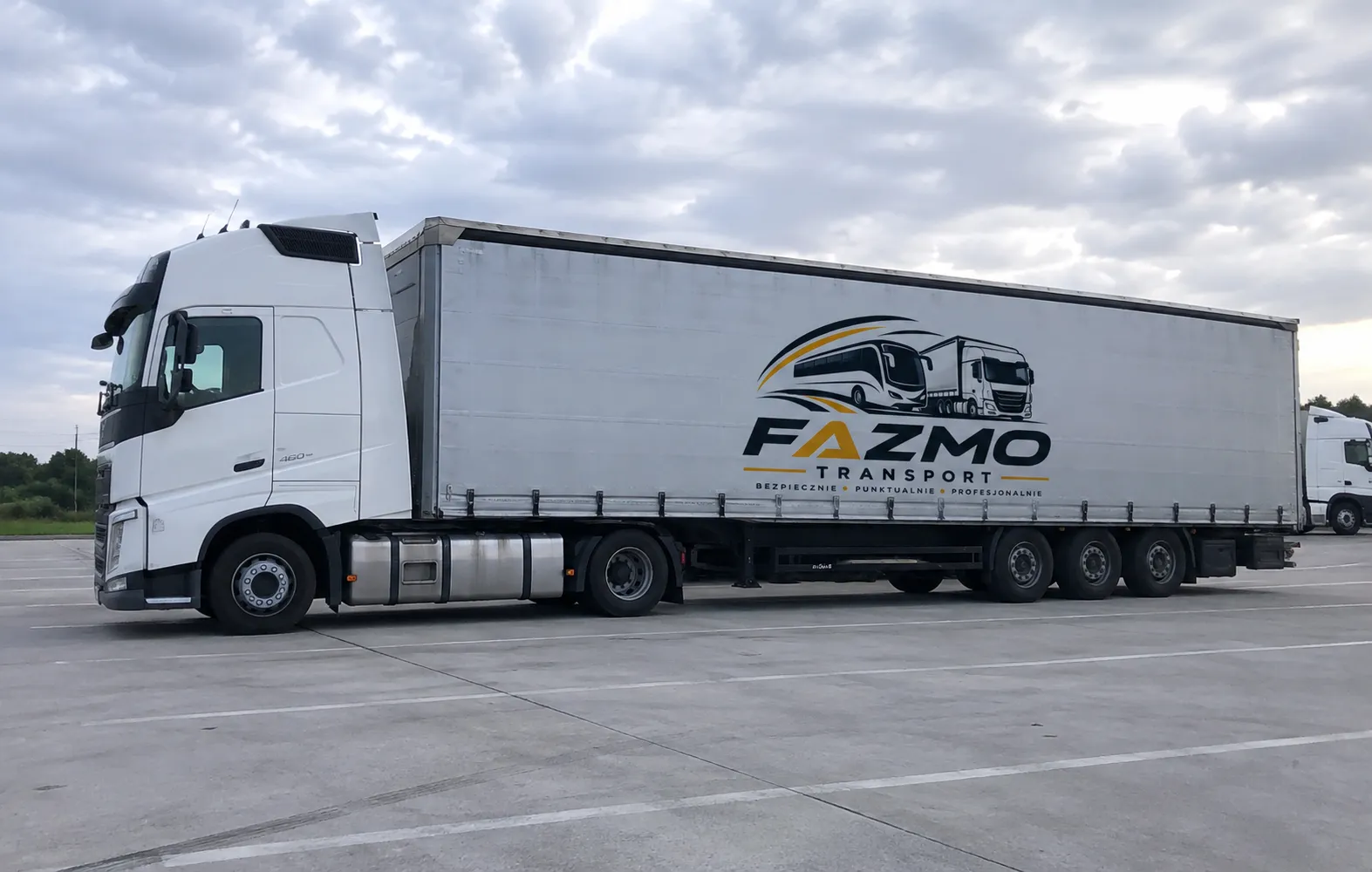Ciągnik Volvo z naczepą firankową Fazmo Transport widziany pod skosem